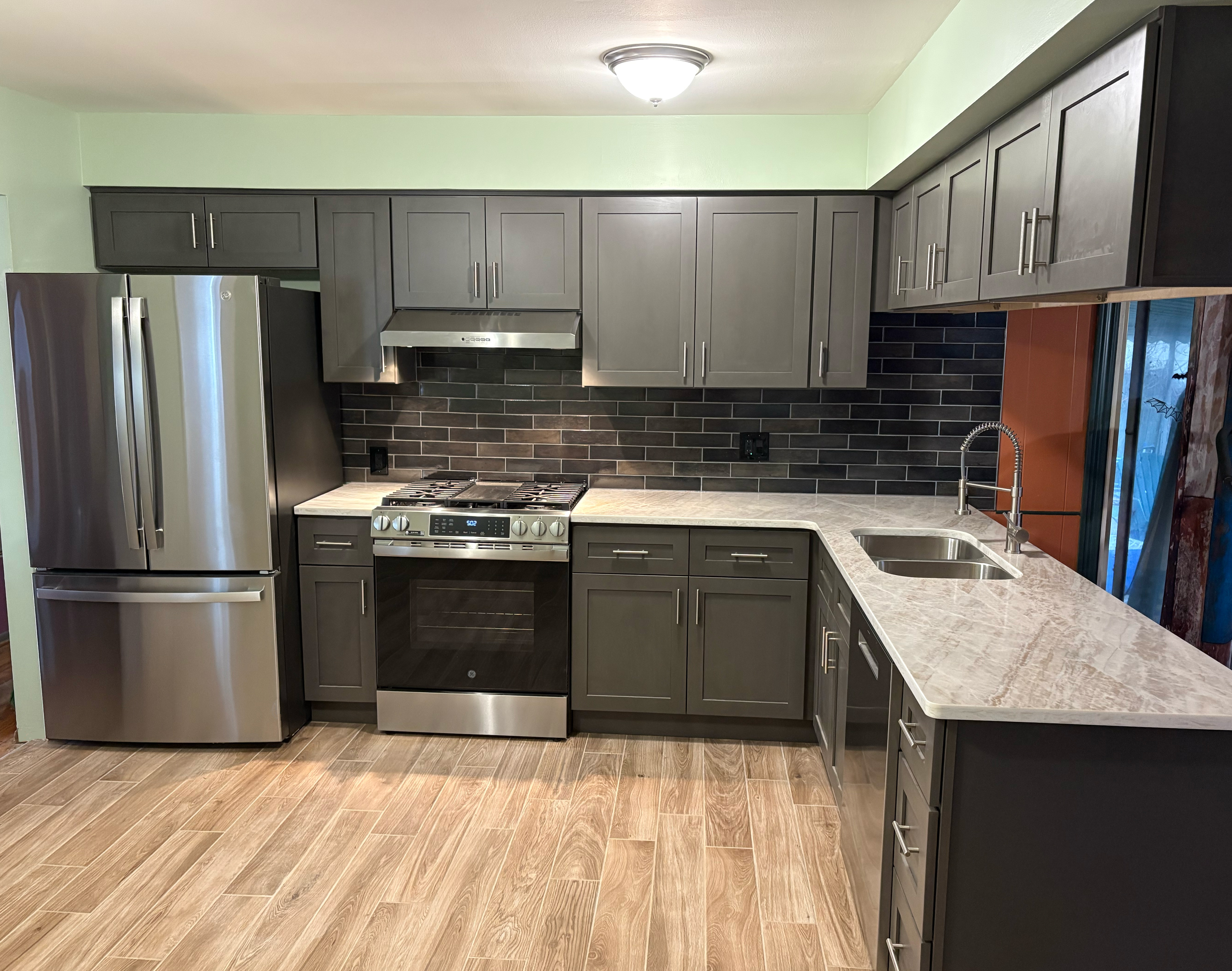 Gray cabinet kitchen remodel with updated counters and tile backsplash